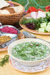 Summer kvass soup (okroshka) on served table with ingredients
