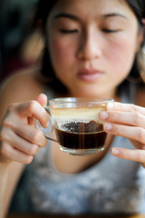 Asian girl drinks black coffee