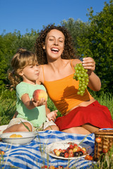 pretty Little Girl and Young Women keeps  fruits on picnic