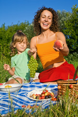 pretty Little Girl and Young Women keeps  fruits on picnic