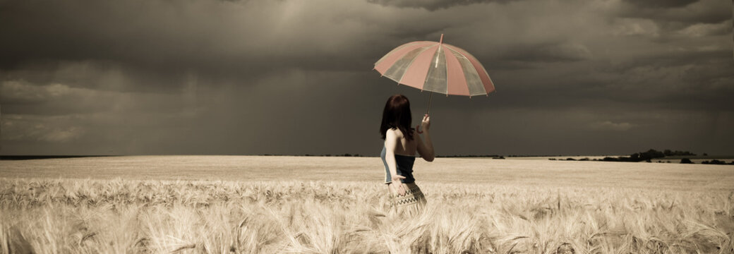 Girl with umbrella at field in retro style panoramic.
