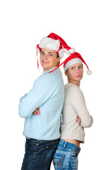 Young couple in santa's hats standing back to back