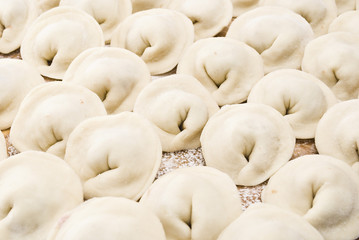 Raw meat dumplings on wooden plate. Closeup