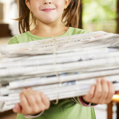 girl recycling newspapers