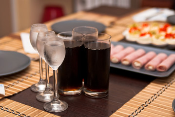 Fototapeta na wymiar three glasses with cold vodka and three glasses of cola