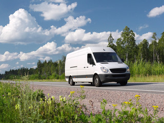 Naklejka premium white van on rural highway, landscape