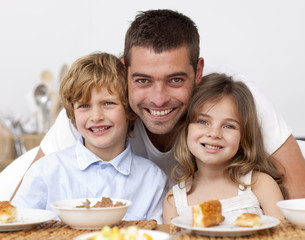 Obraz na płótnie Canvas Children having breakfast with their father