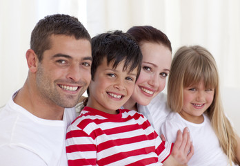 Fototapeta premium Portrait of parents, daughter and son sitting on sofa together