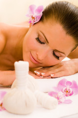 Hübsche Frau bekommt Kräuterstempel Massage