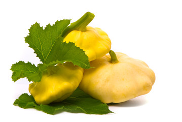 Scallop squash and green leaves on white background