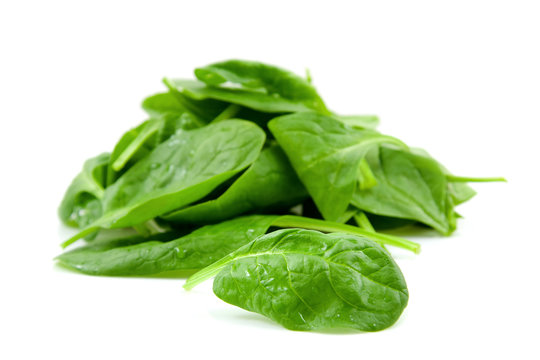 stacked fresh spinach over white backround