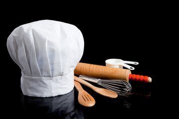 A chef's toque with cooking utensils - obrazy, fototapety, plakaty