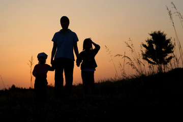 Fototapeta na wymiar mater and children - silhouette by sunset