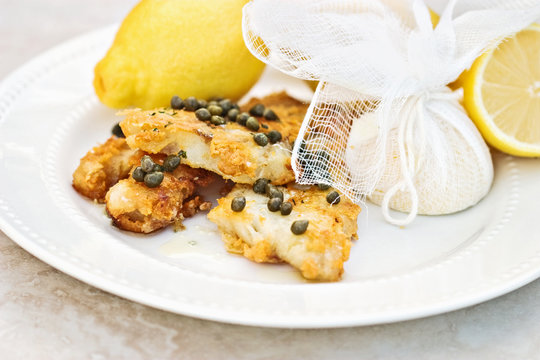 Fish Served With Lemons Tied in Cheesecloth