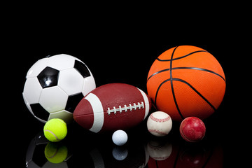 Assorted sports balls on a black background