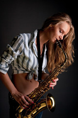 Obraz premium sexy young pretty blonde woman playing saxophone isolated