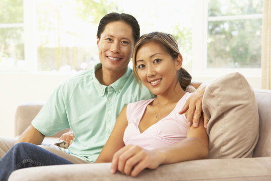 Young Couple Relaxing On Sofa At Home