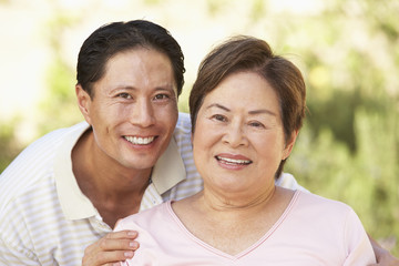 Obraz premium Senior Woman With Adult Son In Garden
