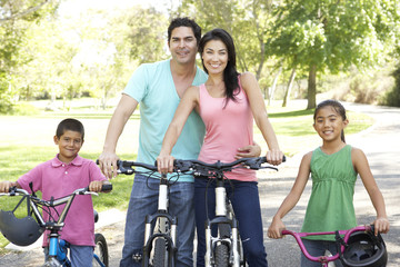 Naklejka premium Young Family Riding Bikes In Park