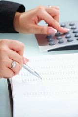 Female hands using calculator