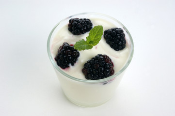 Fototapeta na wymiar some organic blackberries in natural yoghurt and mint