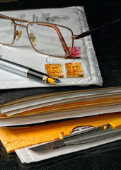 Pen and glasses atop of an envelope
