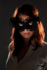 Red-haired woman in a black mask