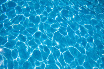 Fototapeta na wymiar Textura de agua en una piscina azul