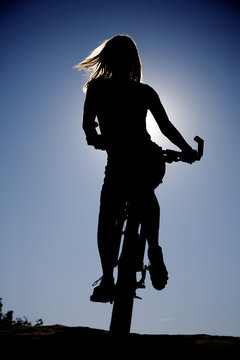 Woman silhouette on bike