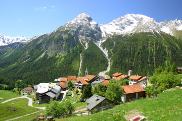 Fototapeta na wymiar Mountain village with snowy peaks in the background