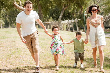 Fototapeta premium Family running with two young children