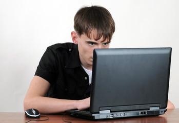 Fototapeta na wymiar Young serious guy is operating his laptop