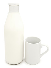 bottle of milk with mug near it