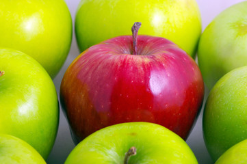 Background of green apples with one red apple