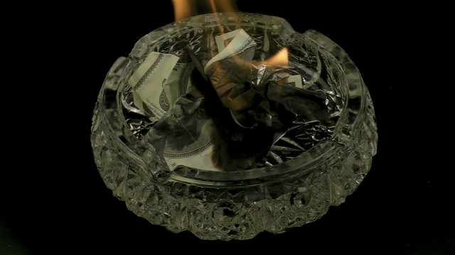 HD 1080p: Burning dollars in ashtray on black background