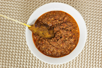 Asian cuisine - Stick of satay dipped in peanut sauce