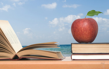 Red apple and books on desk