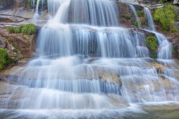 Fototapeta na wymiar Scenic wodospad z białym kaskadzie wodnej w skałach
