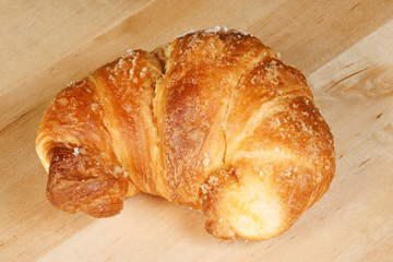 Croissant over wooden background