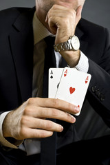 businessman holding two aces