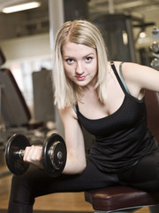 Fototapeta na wymiar Young woman lifting weights