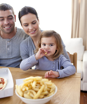 Little Girl Eating Fries And Pizza At Home