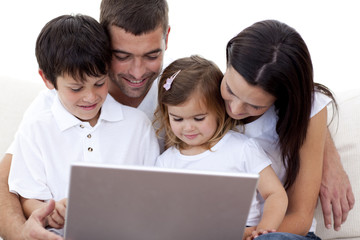Young family using a laptop at home