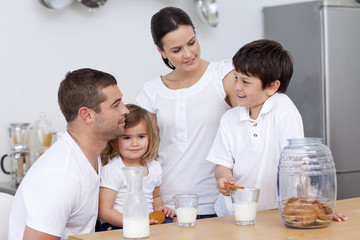 Parents and children eating biscuits and drinking milk