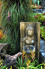Fototapeta premium Buddha Skulptur in Blumengarten