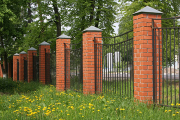 High fence with brick columns