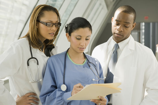 Multi-ethnic doctors and nurse reviewing medical chart