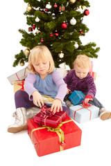 Obraz na płótnie Canvas Christmas - Cute young girls opening their presents