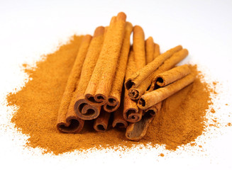Cinnamon powder and sticks isolated on white