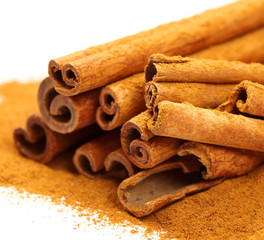 Cinnamon powder and sticks isolated on white